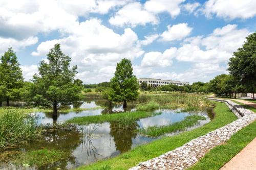 a river with trees and a building in the background at Hilton Garden Inn Austin North in Austin