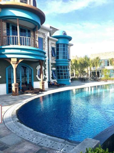 a house with a swimming pool in front of a building at Wonderland Hồ Tràm - Mocha Viva in Ho Tram