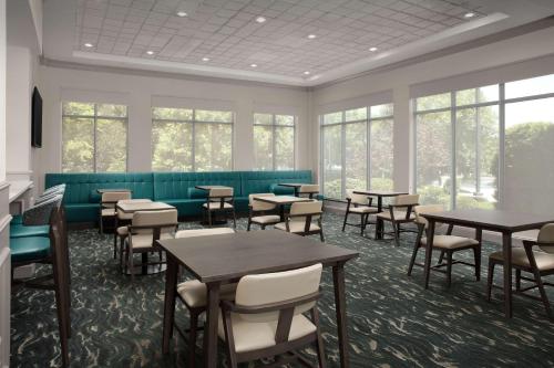 a waiting room with tables and chairs and windows at Hilton Garden Inn Columbia/Harbison in Columbia