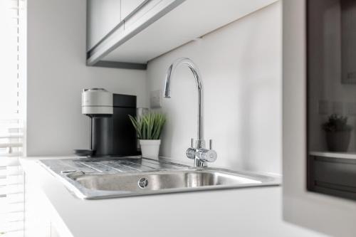 a kitchen with a sink and a coffee maker at StarHost Residences - Brand New 2 bed apartment in Newbury Centre in Newbury
