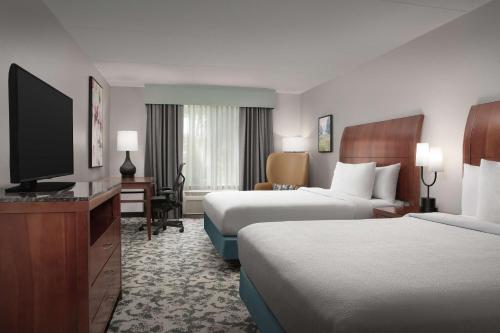 a hotel room with two beds and a flat screen tv at Hilton Garden Inn Columbia/Harbison in Columbia