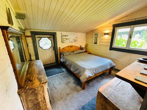 a bedroom with a bed in a wooden room at Hideaway in Lytchett Matravers