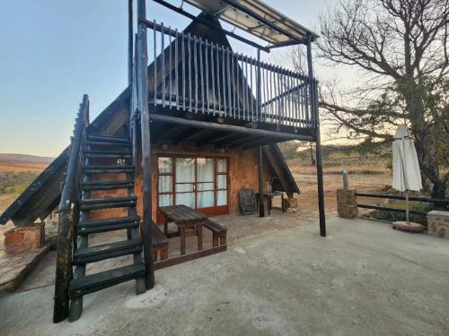 a small cabin with a staircase leading up to it at Tonquani Bush Chalet in Rustenburg