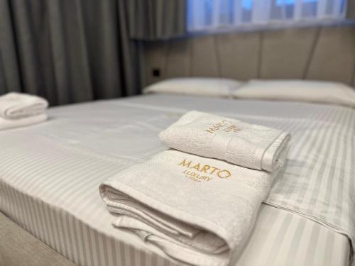 two towels are sitting on top of a bed at Villa MARTO in Sarandë