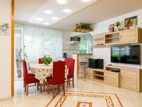 a kitchen and dining room with a table and red chairs at Holiday Home Pentaller by Interhome in Balatonföldvár
