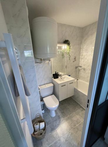 une salle de bain avec toilettes, lavabo et baignoire dans l'établissement Chez Marcel Cabourg Appartement 2 pièces, à Cabourg