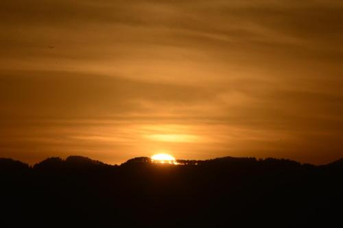 a sunset over a hill with the sun in the sky at Beautiful house and garden in Kathmandu