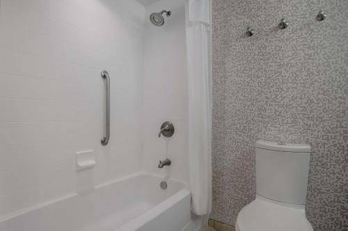 a bathroom with a white tub and a toilet at Home2 Suites by Hilton Destin in Destin