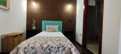a bedroom with a bed with a blue head board at Rilhadas Casas de Campo in Fafe