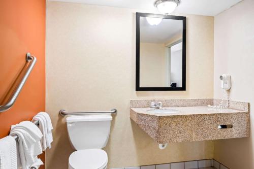 a bathroom with a toilet and a sink and a mirror at Sleep Inn Billings in Billings