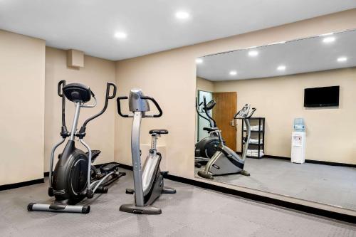 a gym with three exercise bikes and a mirror at Sleep Inn Billings in Billings