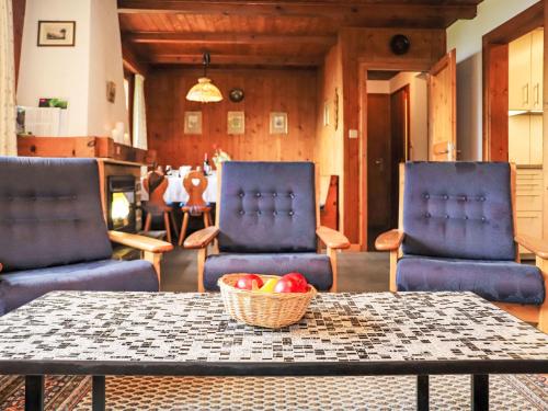 due sedie e un tavolo con un cesto di frutta di Chalet Mungg by Interhome a Nendaz