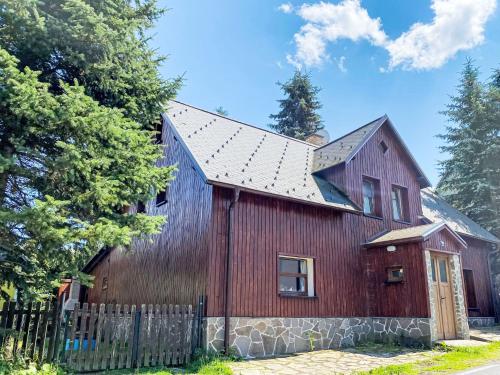 a red barn with a metal roof at Chalet Kovářská by Interhome in Kovářská