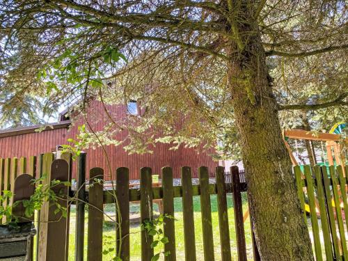 a wooden fence with a tree in front of it at Chalet Kovářská by Interhome in Kovářská