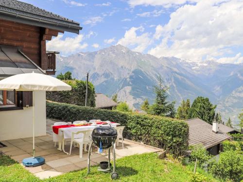 d'une terrasse avec une table, un grill et des montagnes. dans l'établissement Chalet Dorine by Interhome, à Nendaz