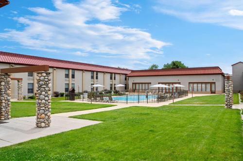 a view of a building with a pool and grass at Comfort Inn at Buffalo Bill Village Resort in Cody