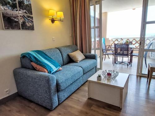 un salon avec un canapé bleu et une table dans l'établissement Studio L'Esquinade - P3 115 by Interhome, à Agay