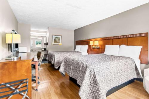 a hotel room with two beds and a desk at Rodeway Inn in Lexington