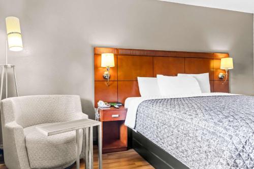 a bed and a chair in a hotel room at Rodeway Inn in Lexington