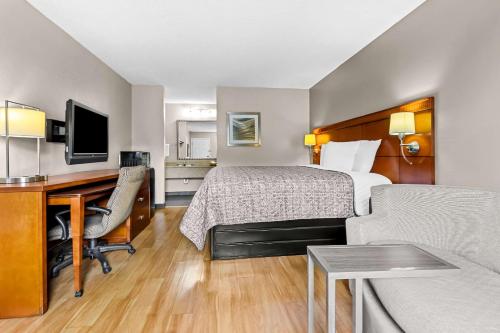 a hotel room with a bed and a desk at Rodeway Inn in Lexington