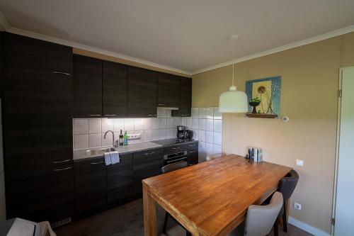 a kitchen with a wooden table in a room at 't Eekhoornnest in Soest