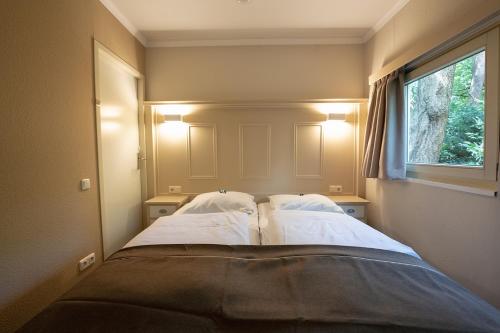a bedroom with a bed with two pillows and a window at 't Eekhoornnest in Soest