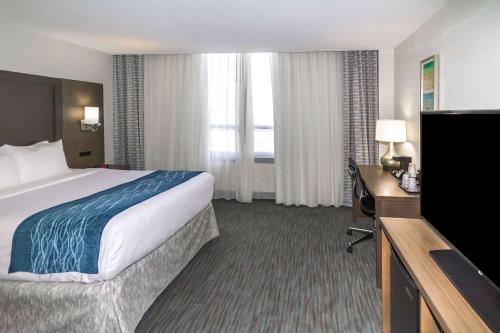 a hotel room with a bed and a flat screen tv at Comfort Inn & Suites Downtown Brickell-Port of Miami in Miami