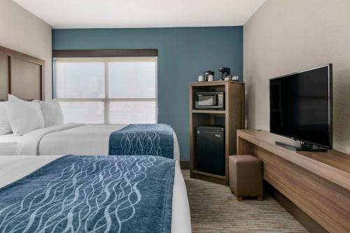 a hotel room with two beds and a flat screen tv at Comfort Inn & Suites Downtown Brickell-Port of Miami in Miami