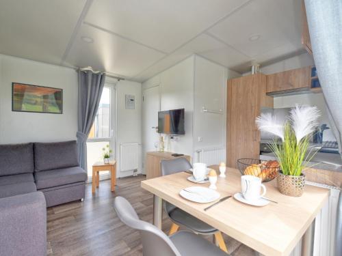 ein Wohnzimmer mit einem Tisch und einem Sofa in der Unterkunft Holiday Home Tiny Haus Lieblingsplatz by Interhome in Beilngries