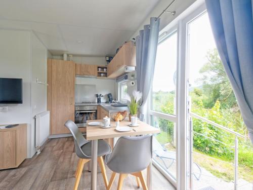 eine Küche mit Tisch und Stühlen und einem großen Fenster in der Unterkunft Holiday Home Tiny Haus Lieblingsplatz by Interhome in Beilngries