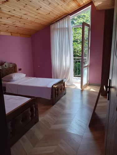 a bedroom with two beds and a large window at Golden Heart in Batumi