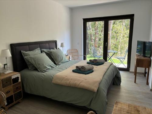 une chambre avec un grand lit avec des serviettes dessus dans l'établissement Villa Les Roches du Montélit, à Saint-Paul-Trois-Châteaux