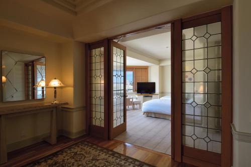 a bedroom with a bed and a door with glass panels at The Naha Terrace in Naha