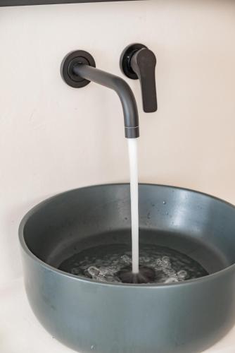 a pan with water running from a faucet at Rania Apartments Sea View in Mýkonos City