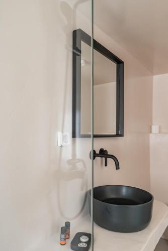 a bathroom with a black sink and a mirror at Rania Apartments Sea View in Mýkonos City