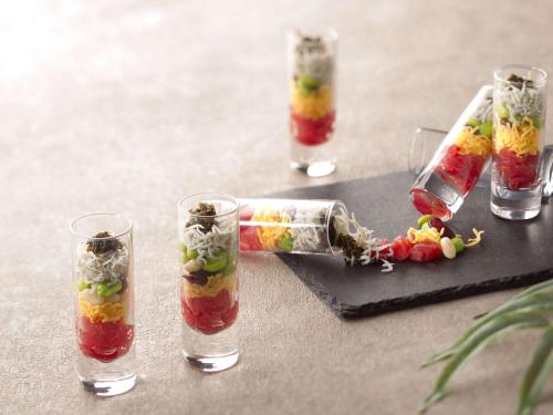 a table with four glasses and a bottle filled with fruit at Grand Mercure Ise-shima Resort & Spa in Shima