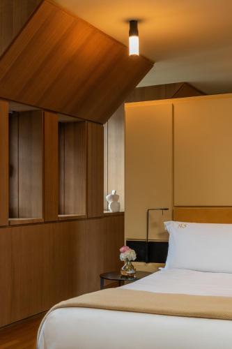 a bedroom with a large bed with a wooden headboard at Hotel Cafe Royal in London