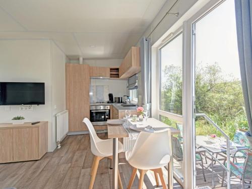 Una cocina y un comedor con mesa y sillas. en Holiday Home Tiny Haus Altmühlblick by Interhome, en Beilngries