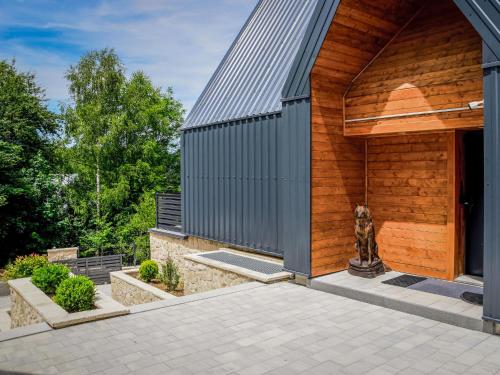a house with a wooden facade with a courtyard at Holiday Home Vuk by Interhome in Kupjak