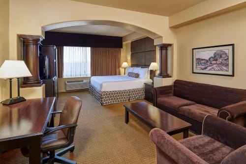 a hotel room with a bed and a living room at Radisson Hotel El Paso Airport in El Paso