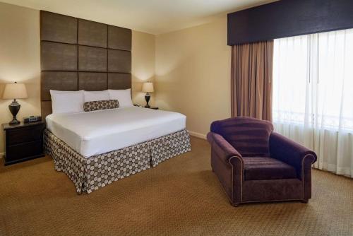 a hotel room with a bed and a chair at Radisson Hotel El Paso Airport in El Paso