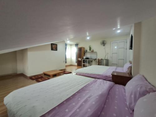 a large bedroom with two beds with purple sheets at MrLee Dalat House in Da Lat