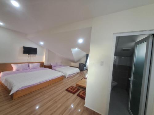 a bedroom with two beds and a walk in shower at MrLee Dalat House in Da Lat