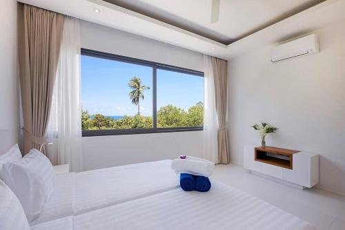 1 dormitorio blanco con 1 cama grande y ventana en SUNWAY 2BD Modern Townhouse, en Koh Samui 