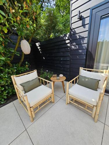 two chairs and a table on a patio at Bed and Breakfast Bij ons in het bos in Bergen op Zoom
