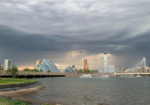 a view of a river with a city in the background at Отель у Ботанического Сада, в самом центре in Astana