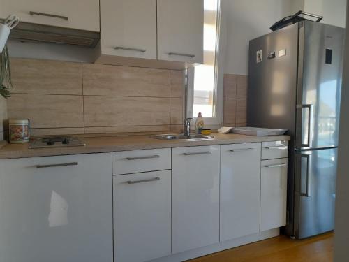 een keuken met witte kasten en een roestvrijstalen koelkast bij Apartment Dunja in Omiš