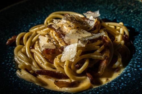 a plate of pasta with cheese and other ingredients at Heliotrope Hotels in Mytilini