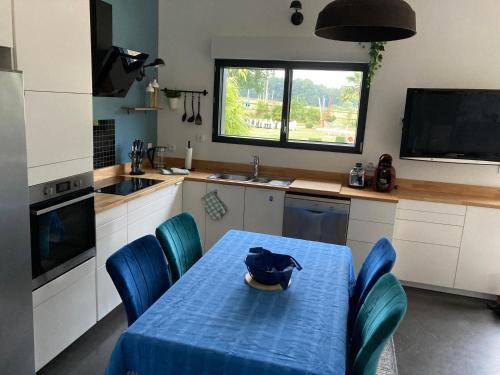 une cuisine avec une table et un chiffon bleu dans l'établissement Au carrefour de la Bretagne, à La Motte
