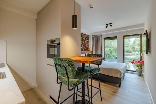 a hotel room with a bed and a table and chairs at Htel Serviced Apartments Amstelveen in Amstelveen